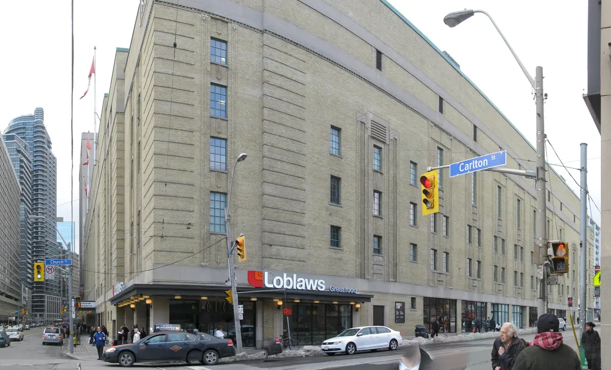 Stone-faced east facade of the former Maple Leaf Gardens, with a Loblaws storefront at street level