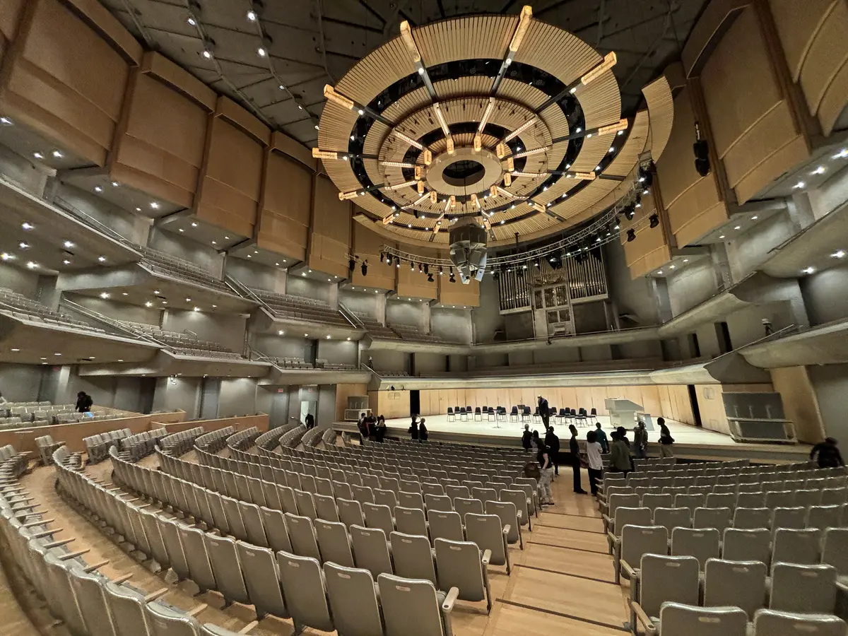 Rows of seats facing the stage under a round wooden ceiling canopy in the main hall of Roy Thomson Hall