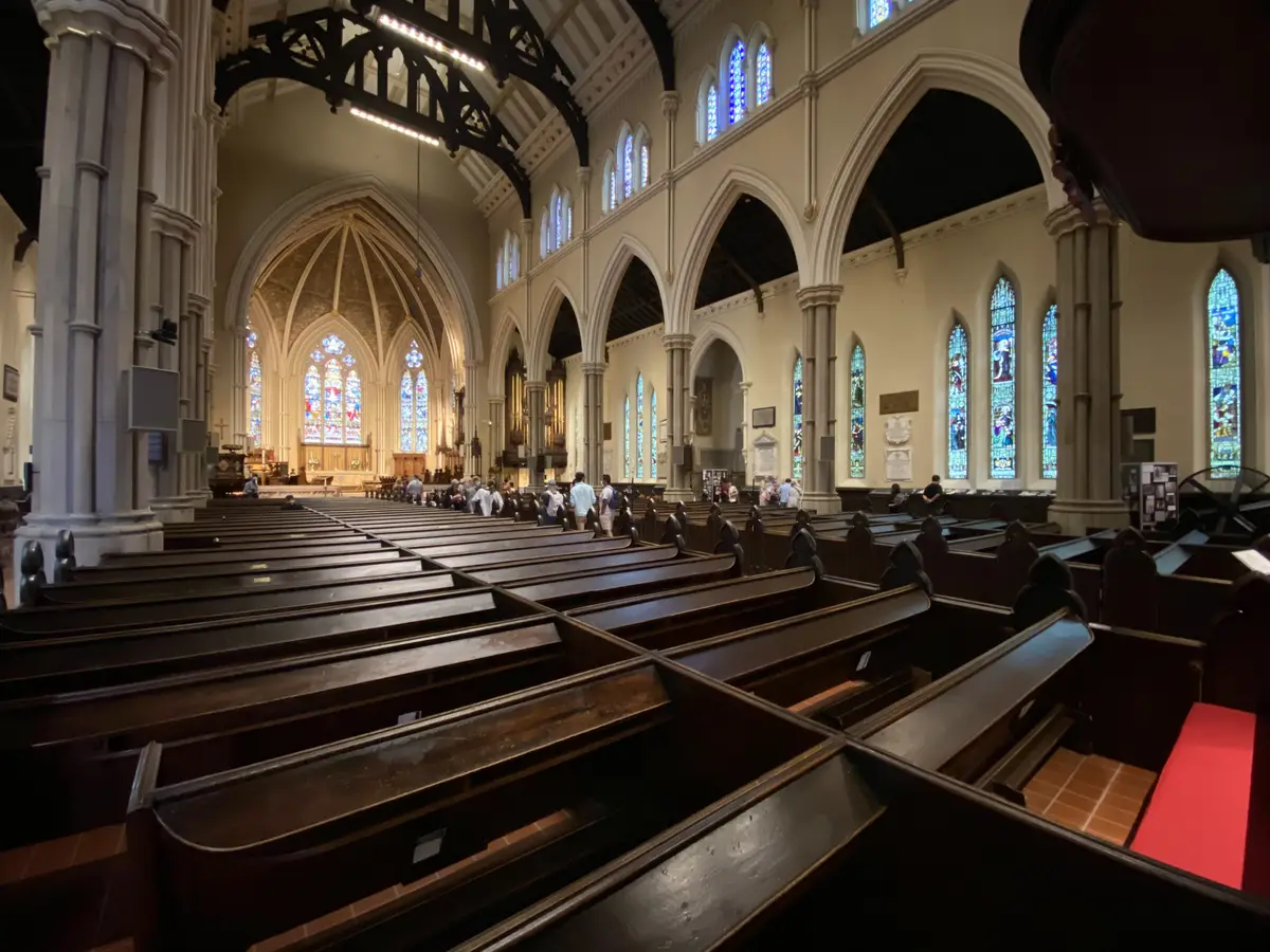 Wooden pews and pointed stained-glass windows inside the Cathedral Church of St. James in Toronto