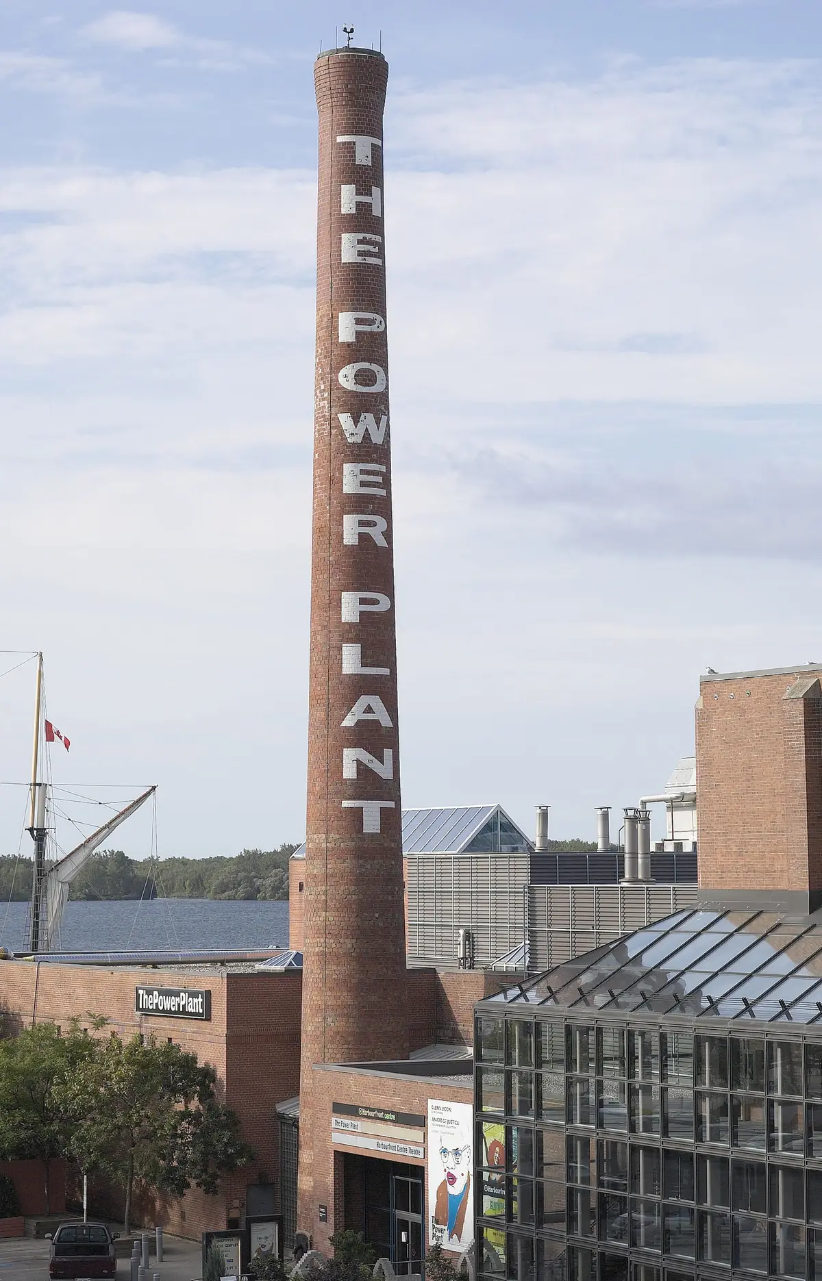 Tall brick chimney with THE POWER PLANT lettered down its length, above the gallery buildings.