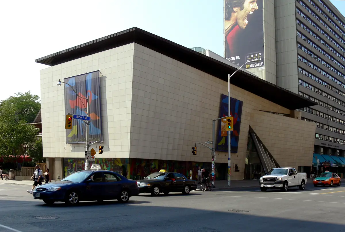 The Bata Shoe Museum building on Bloor Street West, with banners on its walls, a traffic light on the corner and taxis on the street