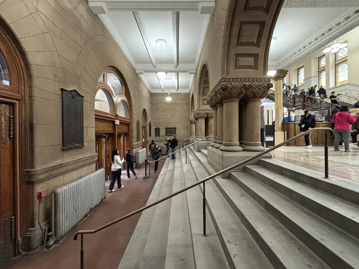 Broad steps in the foyer of Old Toronto City Hall, with ornate columns and arched doorways