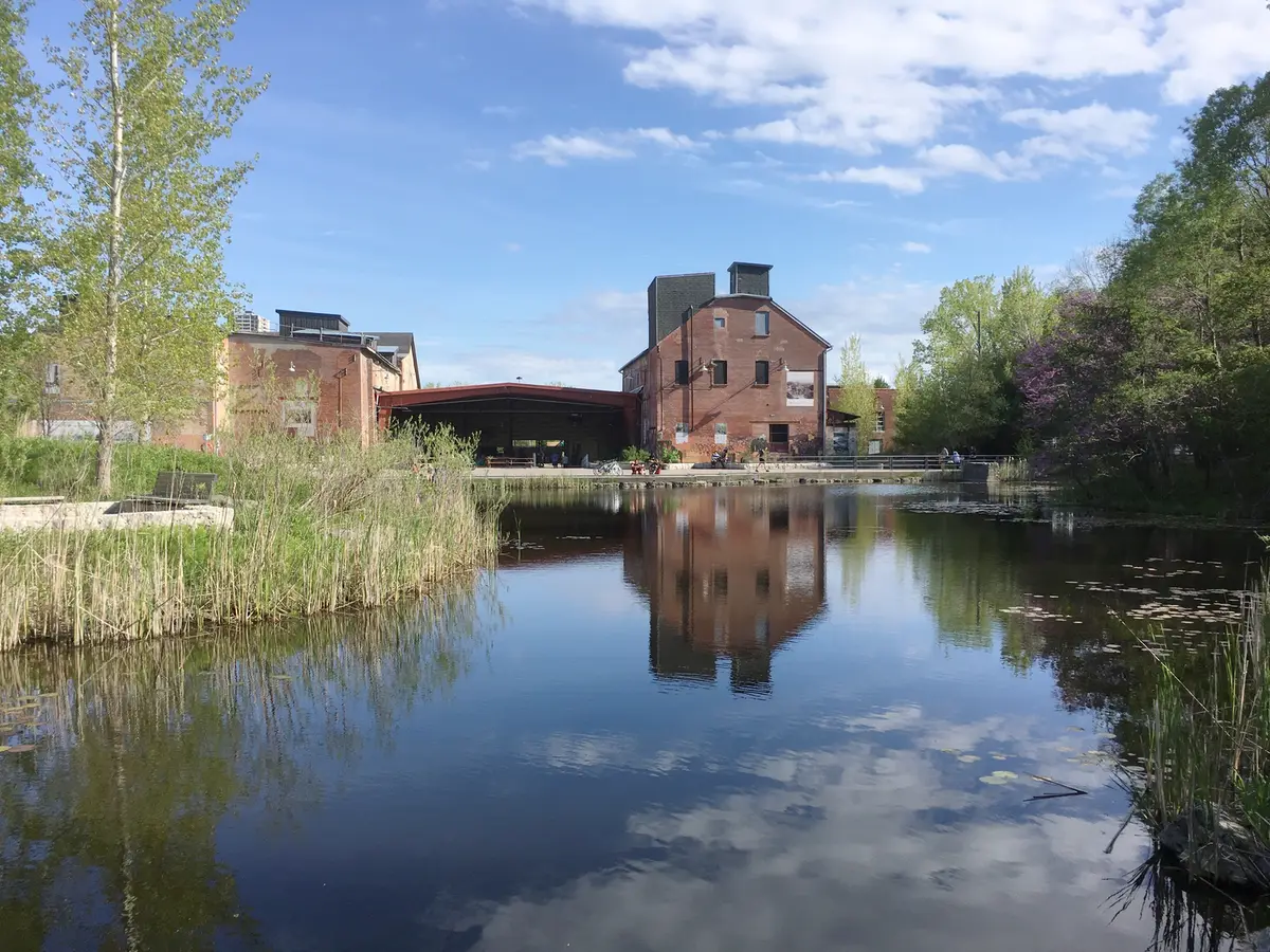 Heritage brick buildings reflected in a pond at the Don Valley Brick Works