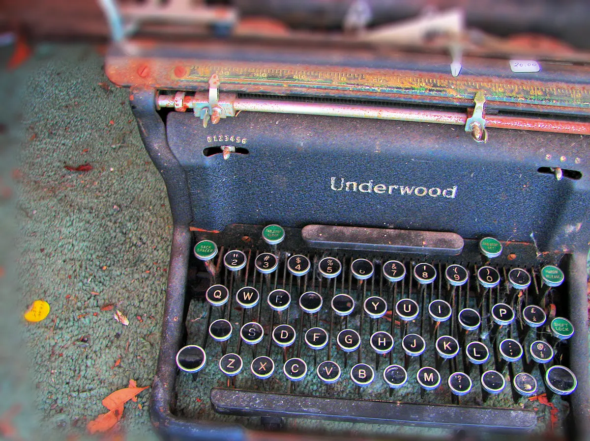 An old Underwood typewriter with a price tag, set on a carpet.