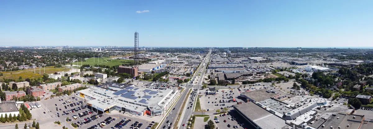 Aerial panorama looking along Eglinton Avenue East across large retail buildings and surface parking in the Golden Mile.