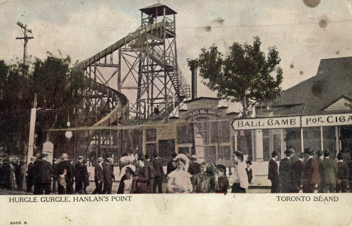A hand-tinted postcard, circa 1910, of the Hurgle Gurgle ride and ball game stalls at Hanlan's Point, with crowds in period dress