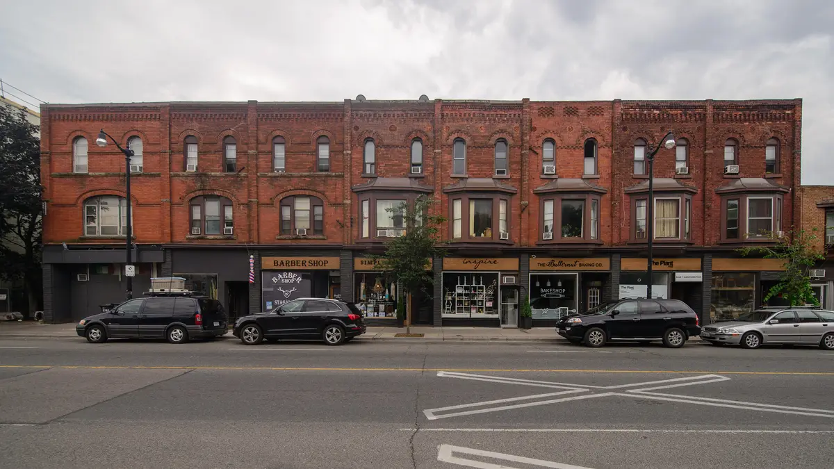 A row of red-brick buildings with shopfronts on Dundas Street West in the Junction