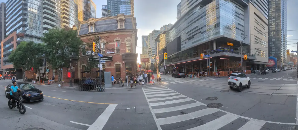 A street corner with crosswalks and a tall glass-fronted building