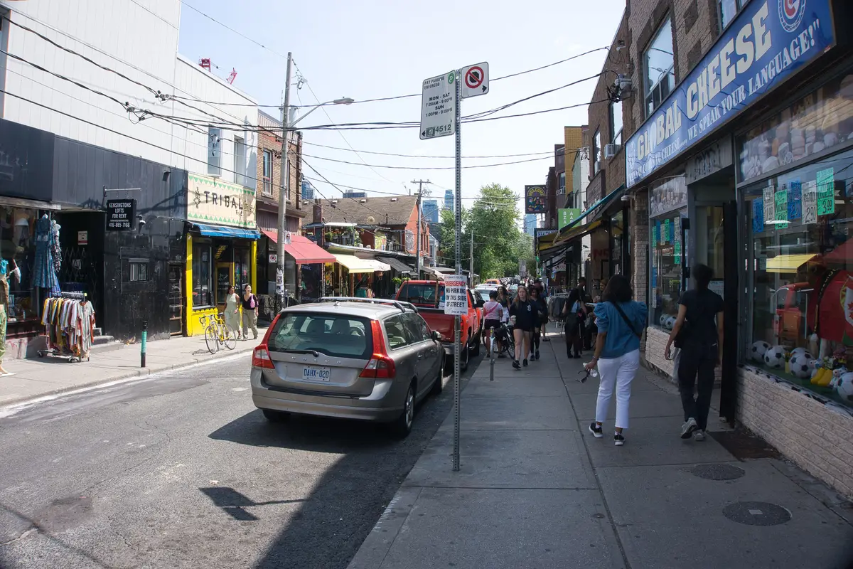 Looking south down Kensington Avenue past shopfronts and pedestrians