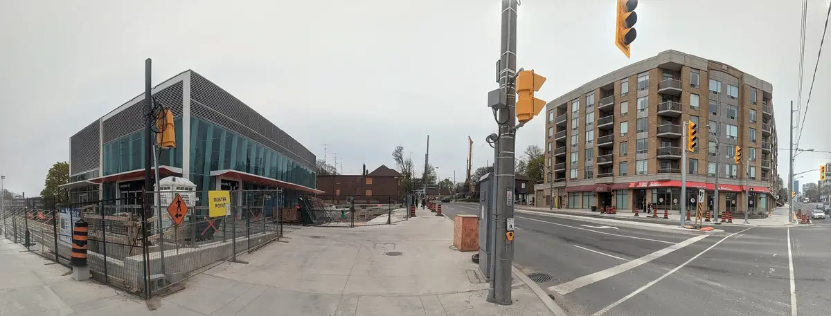 Wide view of the intersection of Bayview Avenue and Eglinton Avenue East with a new glass-fronted building and a condo tower.
