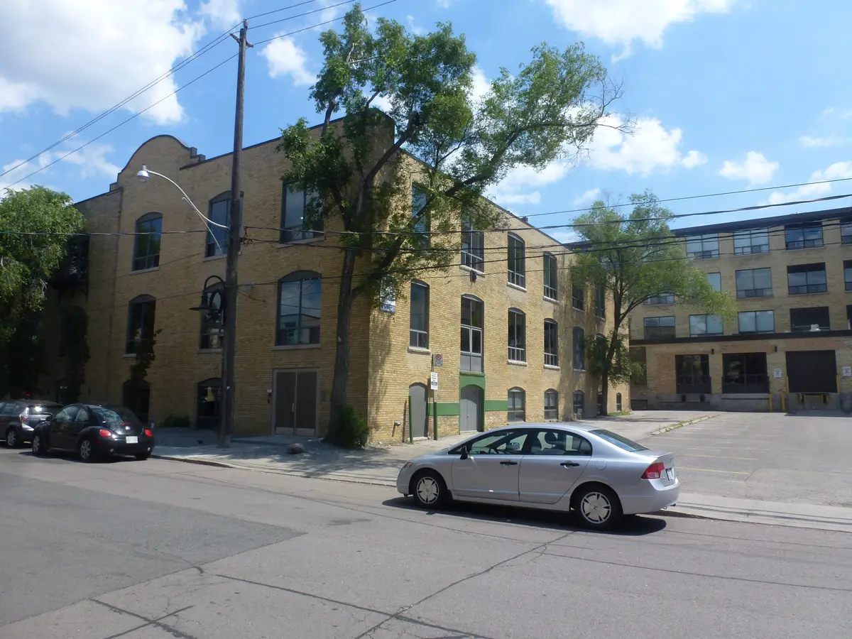 A three-storey yellow-brick former factory with arched windows on Atlantic Avenue in Liberty Village on a sunny day