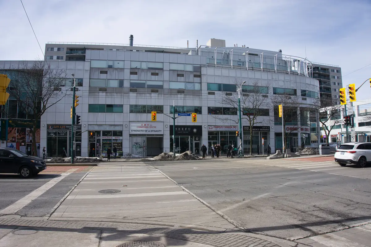 A white multi-storey mall with a Chinatown Centre sign, beside a street intersection.