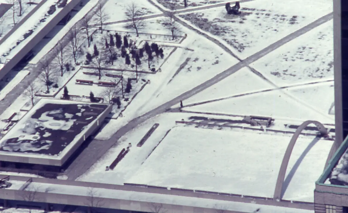 A lone pedestrian crosses the snowy plaza at Nathan Phillips Square