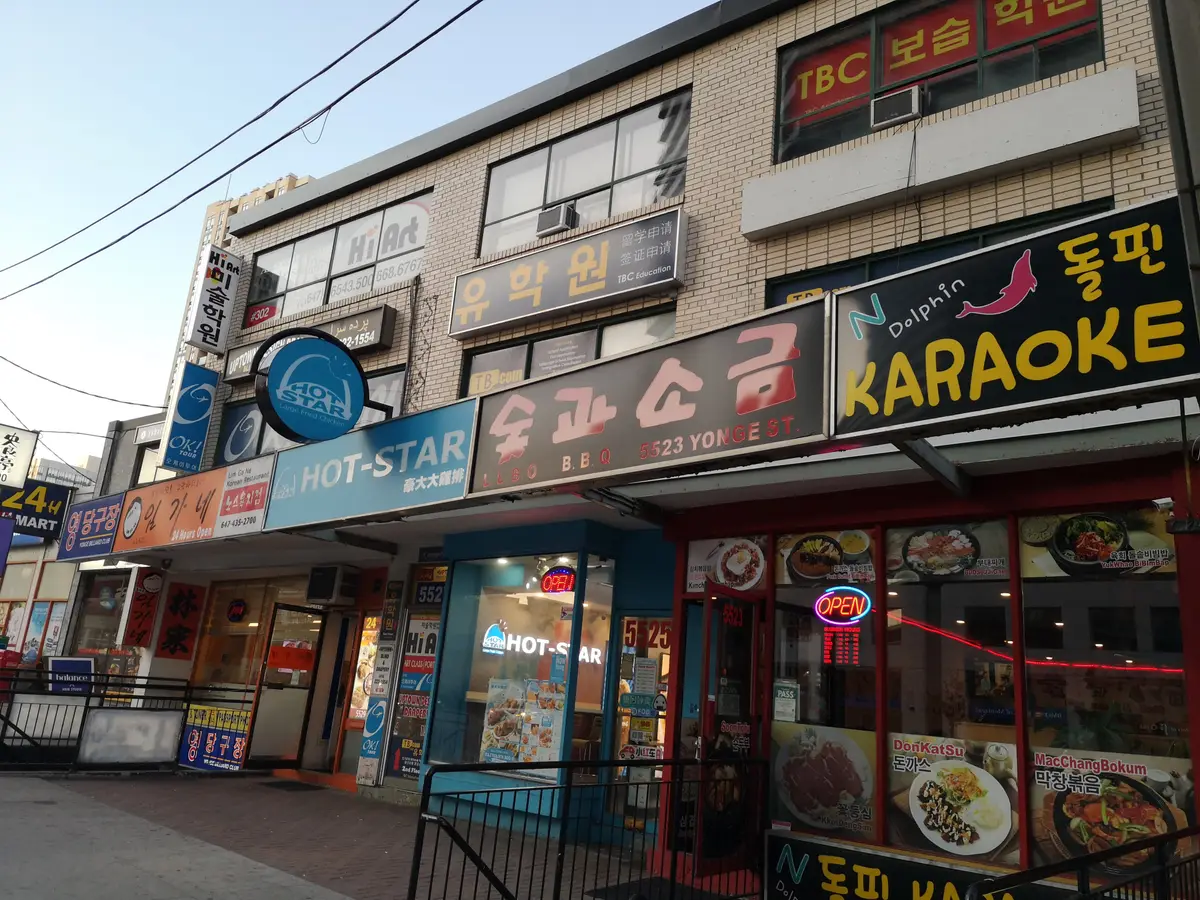 Storefronts with Korean and English signs, including a karaoke bar, along Yonge Street near Olive Avenue in Willowdale
