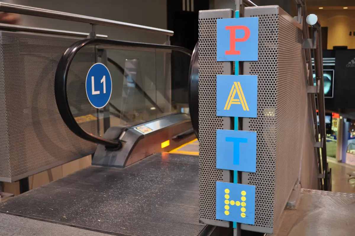 A PATH sign beside an escalator in an underground shopping concourse