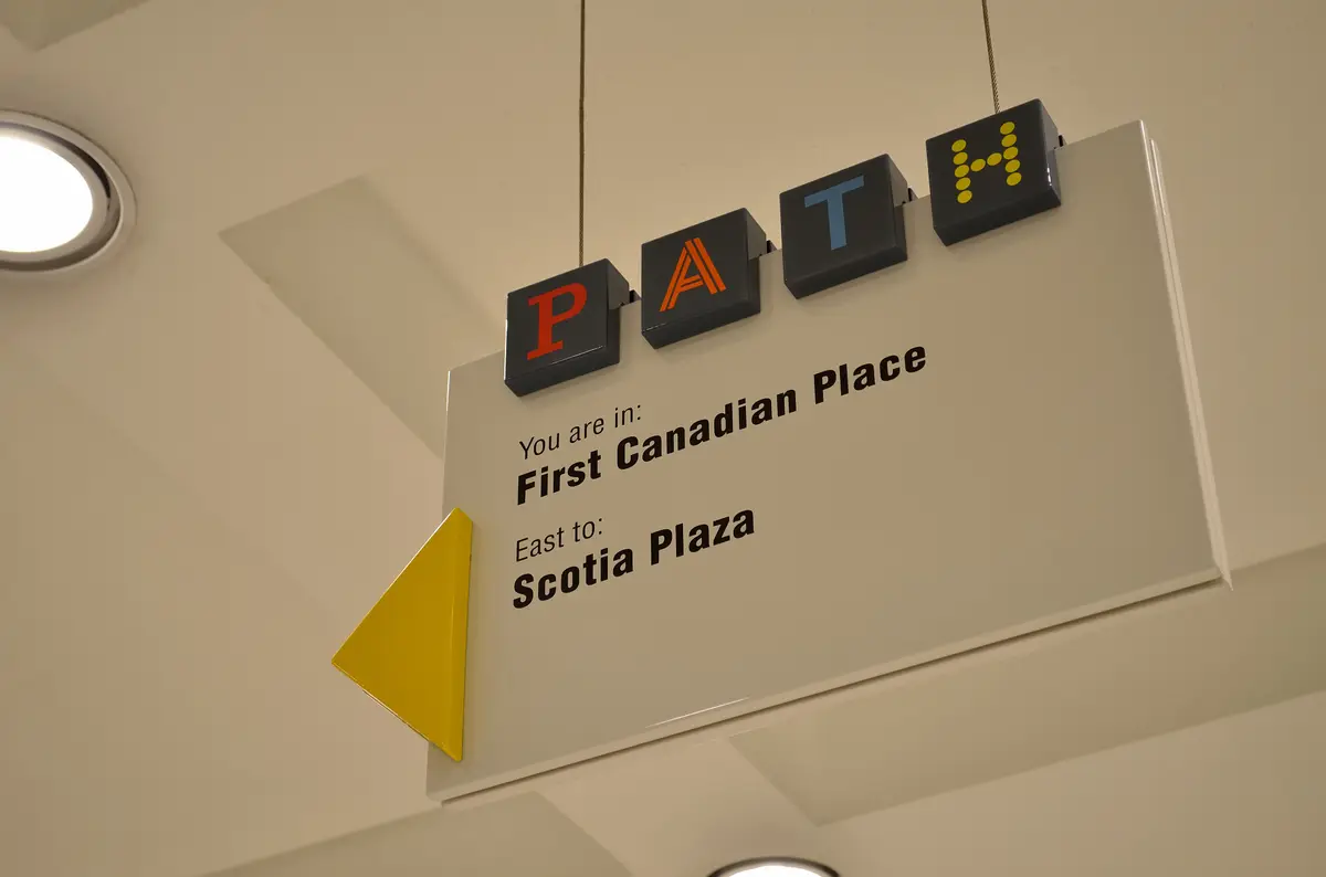 A hanging PATH sign in First Canadian Place pointing east to Scotia Plaza