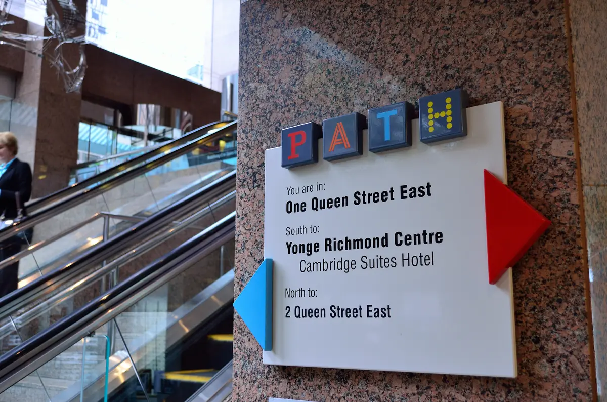 A PATH wayfinding sign showing directions to Yonge Richmond Centre and 2 Queen Street East