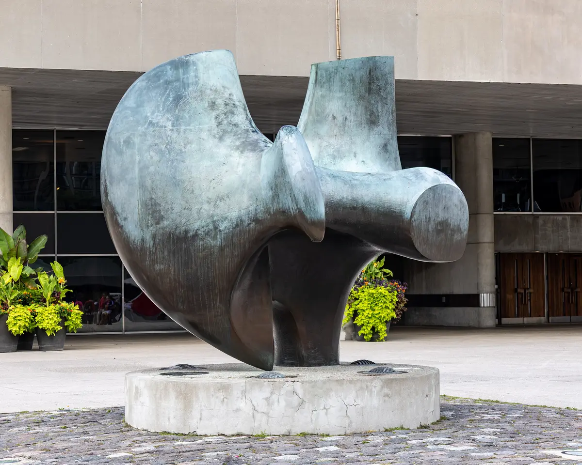 Henry Moore's sculpture The Archer, a large patinated green-grey form on a round concrete base in Nathan Phillips Square