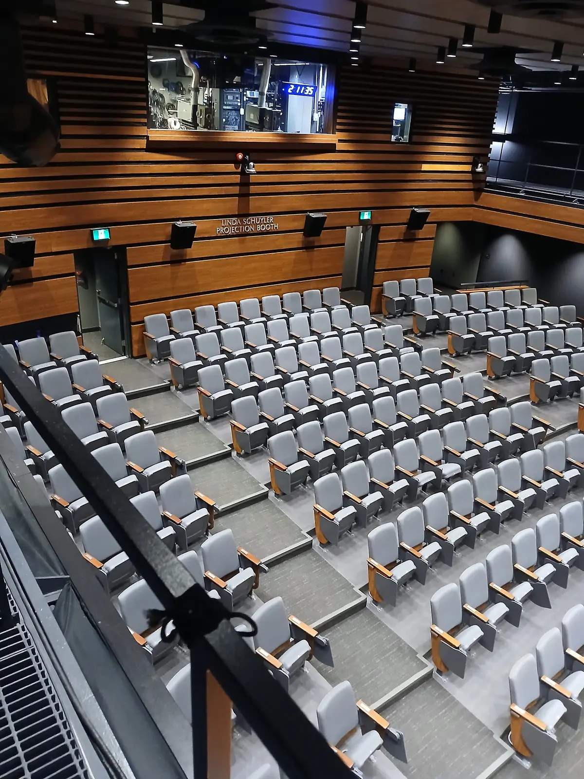 Rows of grey theatre seats stepping down toward a stage inside Innis Town Hall.