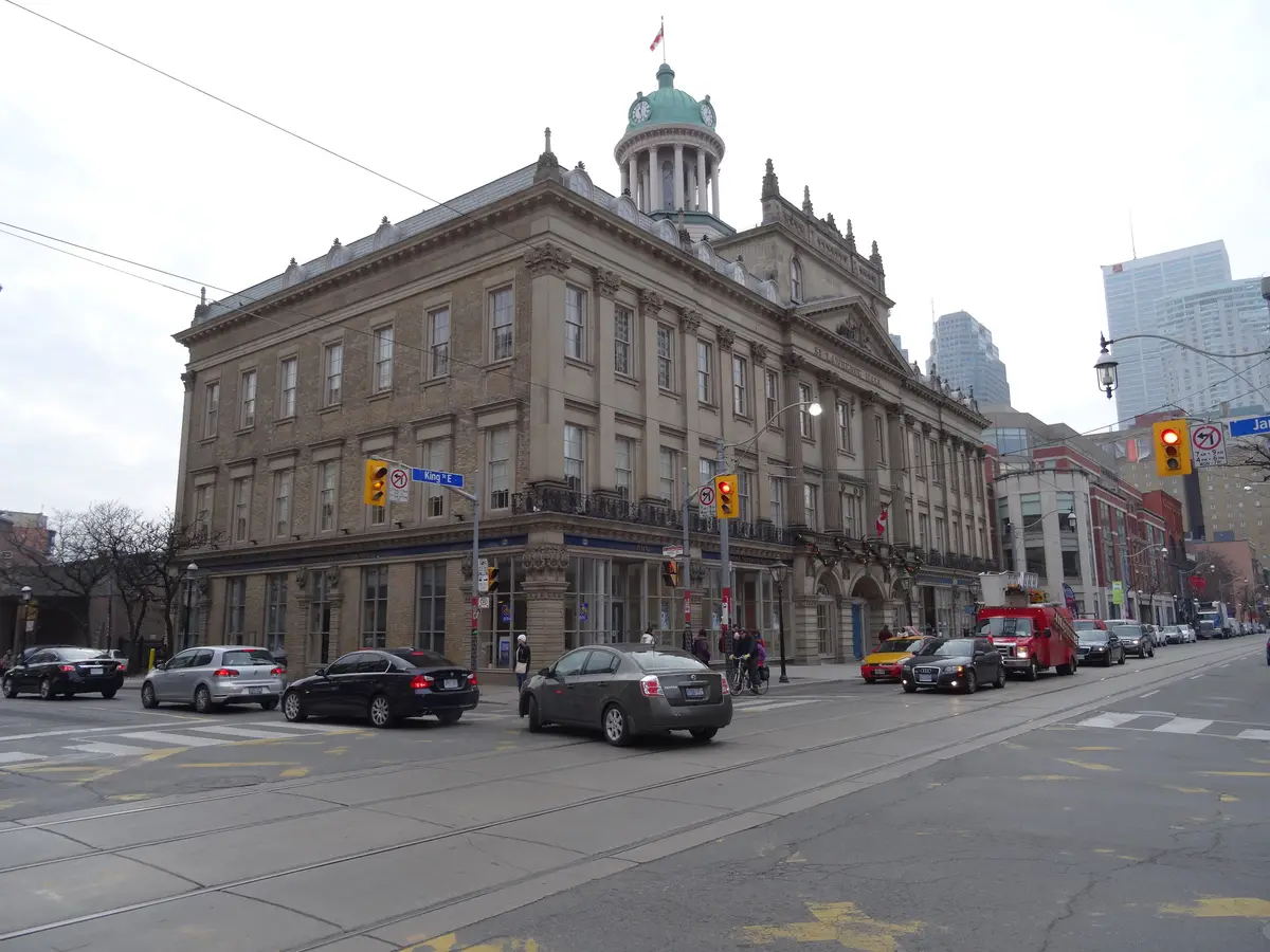 The stone facade and green copper dome of St. Lawrence Hall seen from the corner of King Street East