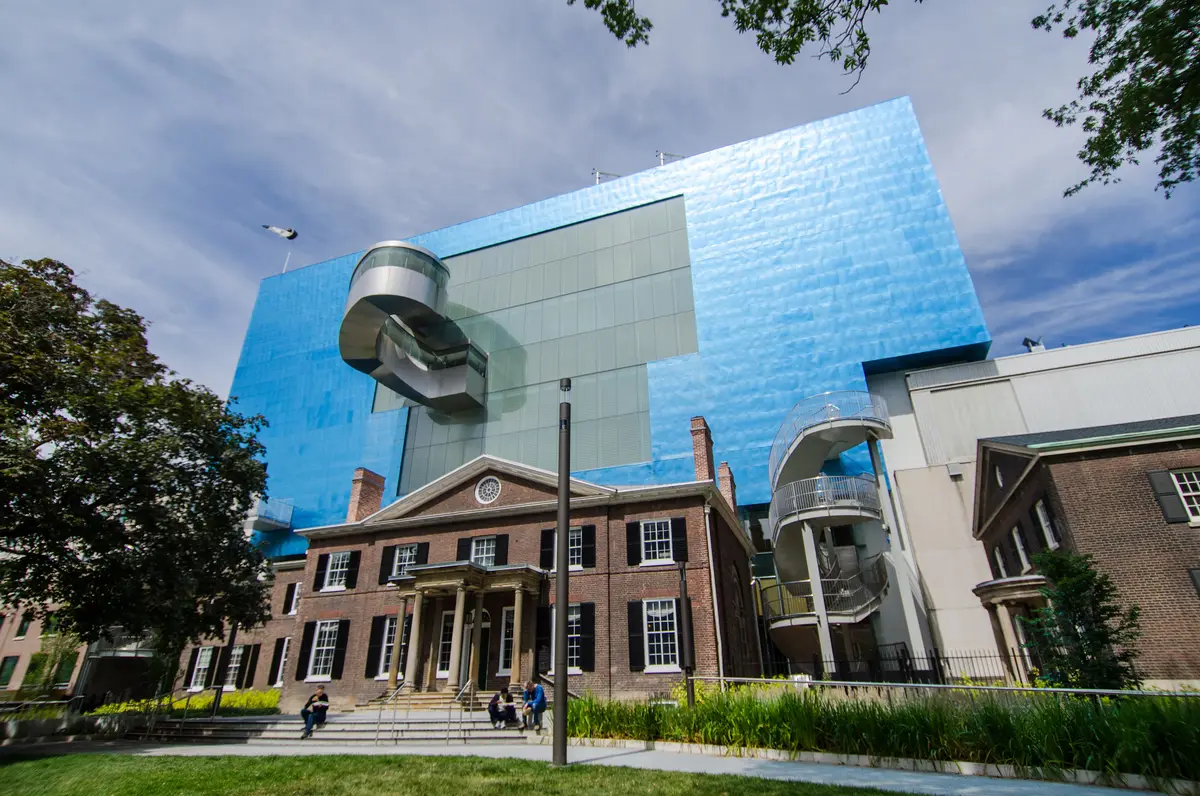 The blue metal facade of the Art Gallery of Ontario rising behind an older brick building
