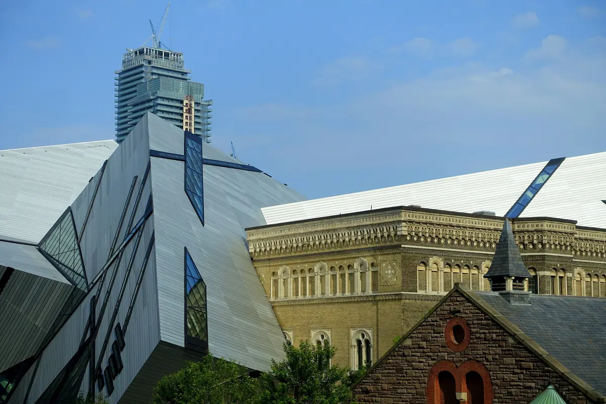 The angular metal and glass Crystal of the Royal Ontario Museum beside a stone heritage wing