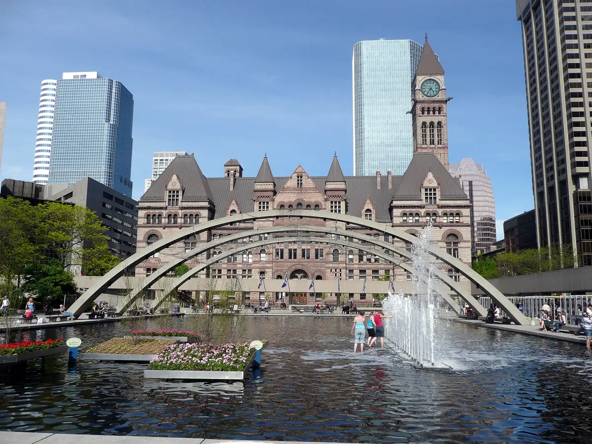 The arches and reflecting pool of Nathan Phillips Square, with the sandstone clock tower of Old City Hall behind