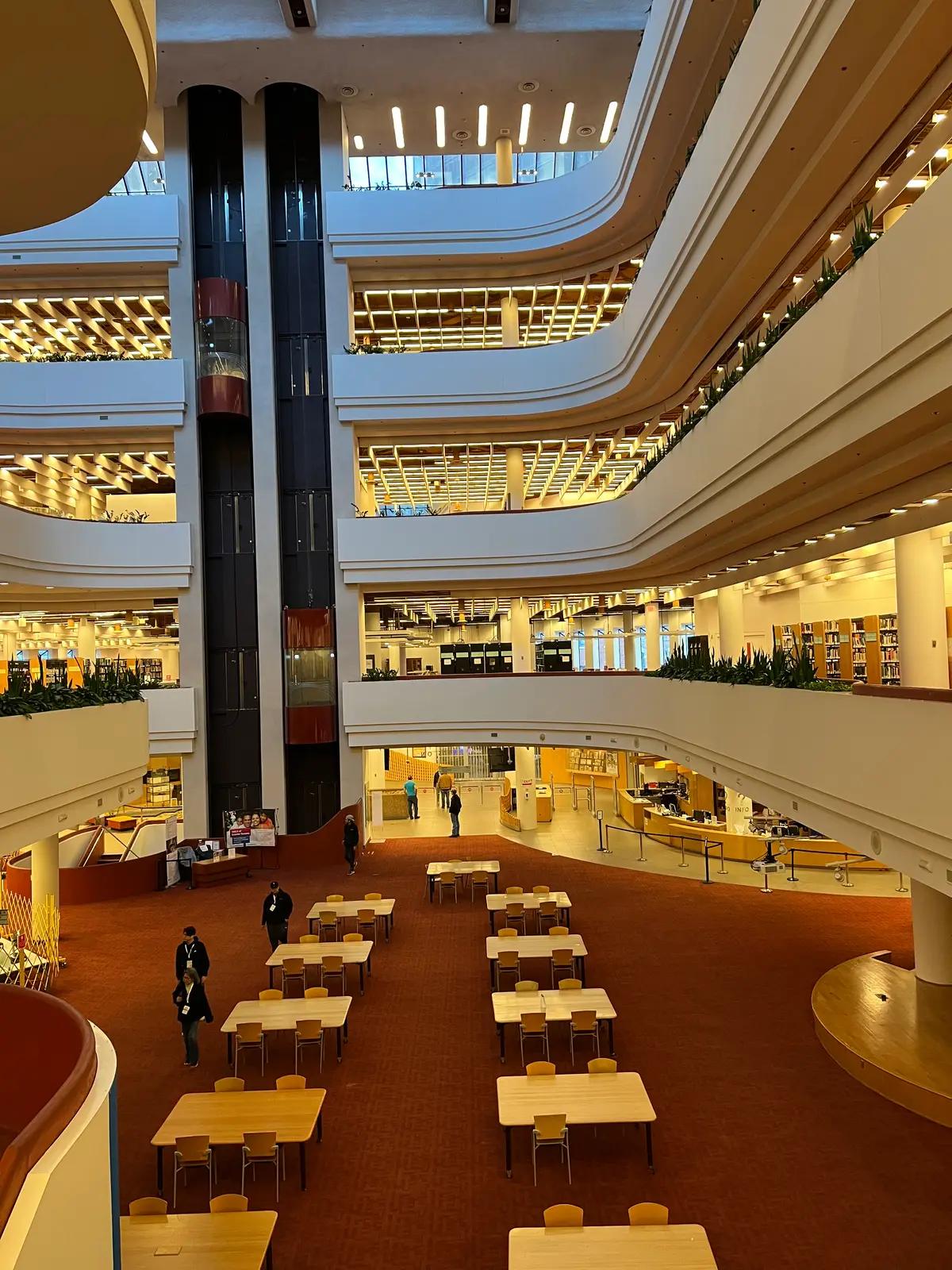 View into the atrium from an upper floor, with stacked balconies, study tables and tall columns